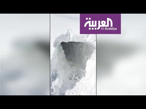 شاهد عراقيون يحفرون أنفاقا في الثلوج للوصول إلى منازلهم